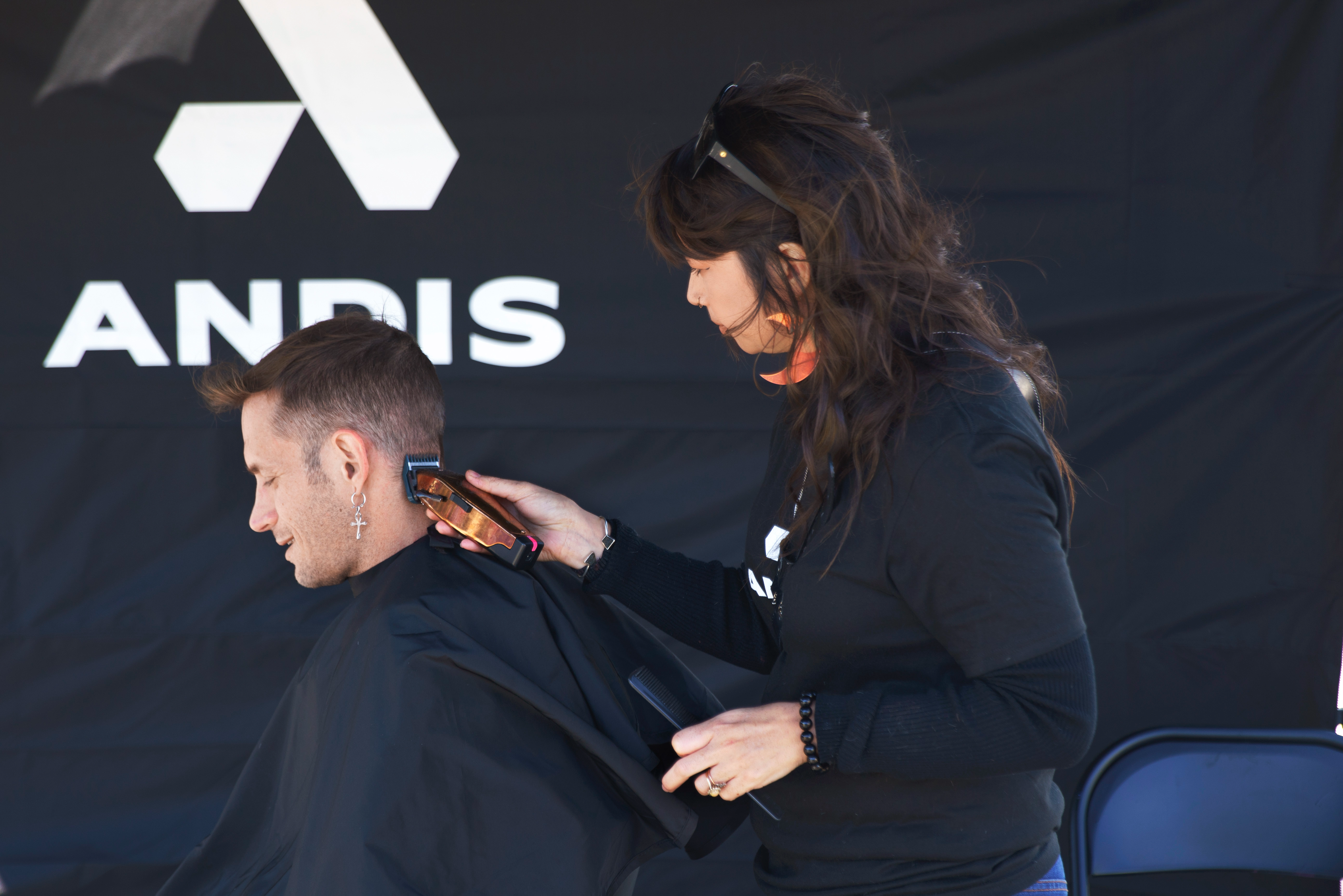 Brighter Community Venice Beach barber clipping hair with copper Master clipper