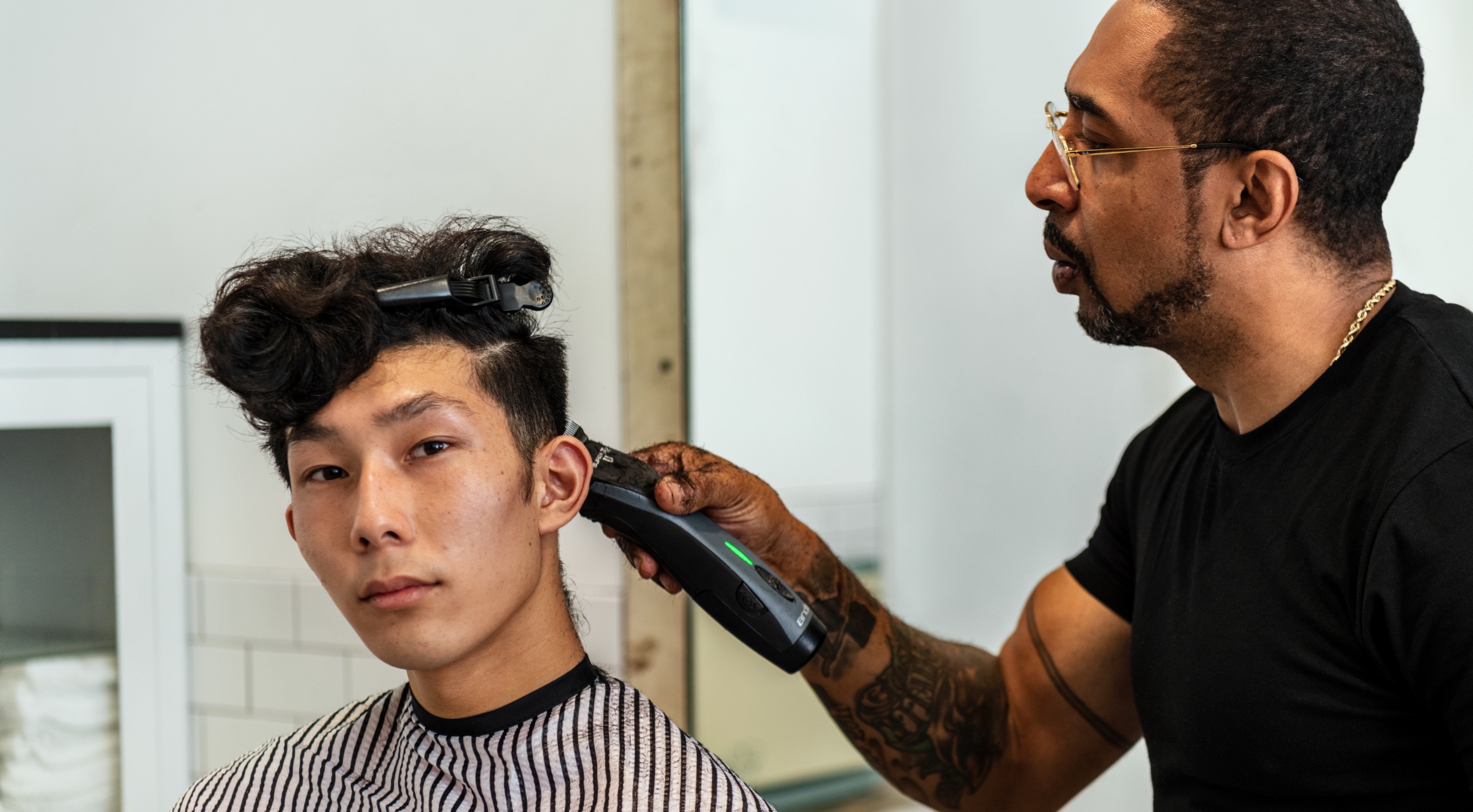 Small image of Young man in barber chair getting hair cut